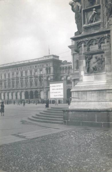 Veduta architettonica. Milano - Piazza del Duomo - Scritta di propaganda bellica allestita sui portici meridionali