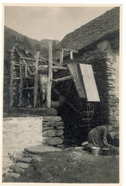 Veduta architettonica. Valle Vigezzo - Donna lava i panni accanto a un mulino