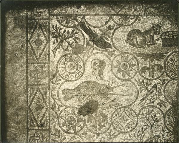 Aquileia - Basilica. Cripta degli Scavi, particolare del mosaico pavimentale raffigurante un aragosta su una pianta, un capro con un cesto di uova e pane, uccelli e motivi geometrici (IV sec.).