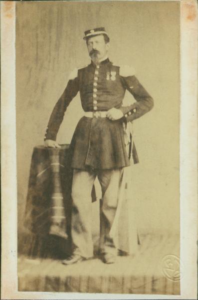 Ritratto maschile - Militare - Ufficiale in uniforme in piedi con la mano appoggiata su un tavolino ricoperto da una tovaglia
