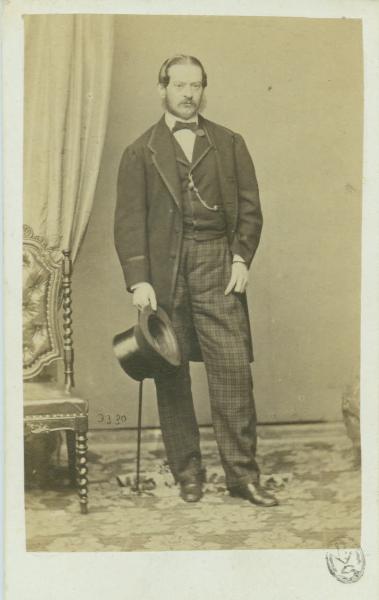 Ritratto maschile - Uomo in piedi con pantaloni a quadri, cappello a tuba e bastone da passeggio