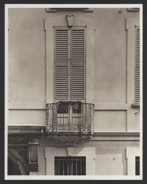 Milano - Palazzo Perego. Facciata, particolare di una porta finestra con balconcino in ferro battuto.