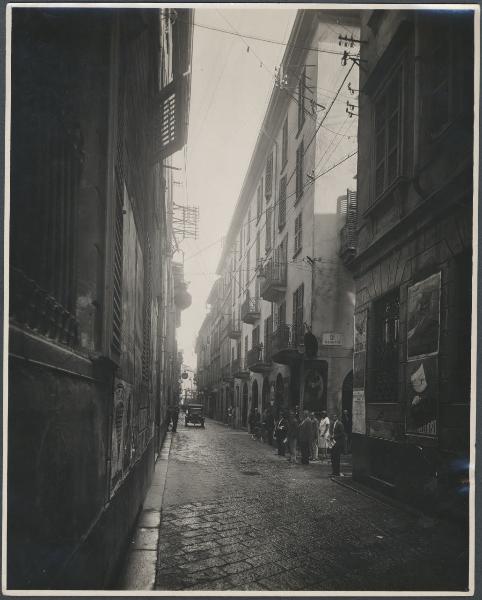 Milano - Via S. Radegonda. Scorcio della via con persone all'angolo di via dei Magnani e auto.