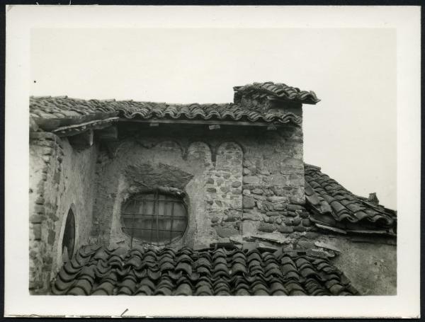 Busano - Chiesa parrocchiale di S. Tommaso. Esterno, particolare di una finestrella sottostante il tetto.