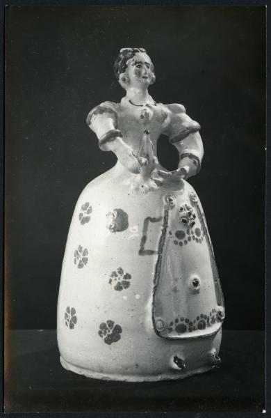 Bari - Raccolta Avv. Maselli. Fiasca in ceramica decorata a forma di donna con abito a fiori della fabbrica di Grottaglie (XVIII sec.).