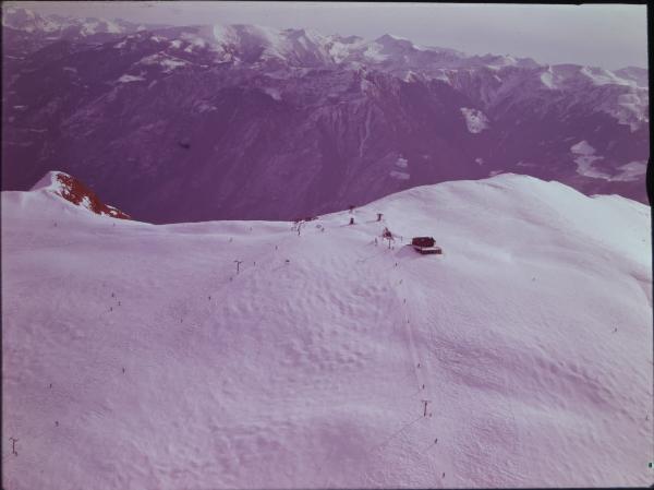 Montagna. Impianto sciistico di risalita. Sciatori. Veduta aerea.