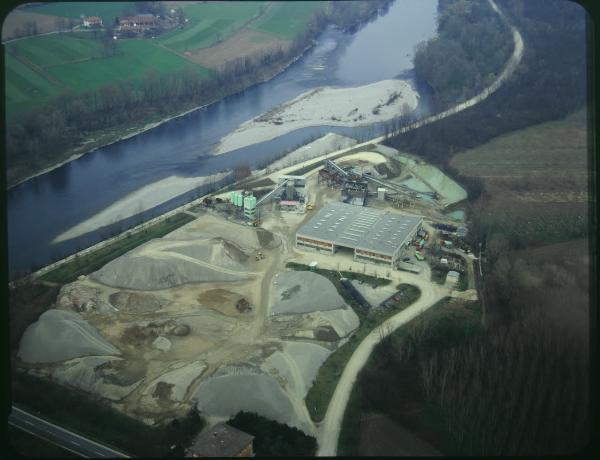 Rivolta d'Adda. Fiume Adda. Sito industriale. Bacini d'acqua. Ponte stradale. Veduta aerea.