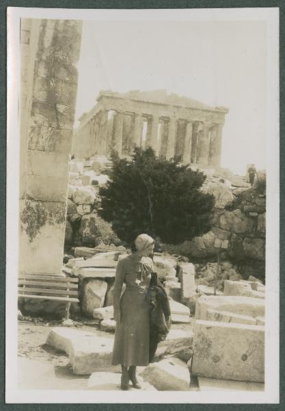 Ritratto femminile - Giovane donna con cappellino a cuffia e soprabito sul braccio - Atene - Acropoli - Sullo sfondo la facciata orientale del Partenone