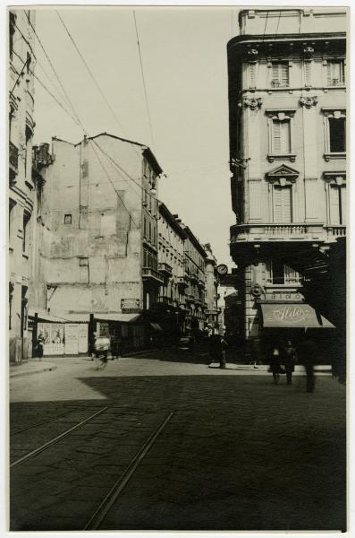 Milano - Via Cavallotti, angolo Via S. Zeno - Manifesti pubblicitari, orologio elettrico, negozio "Aldo", rotaie e passanti