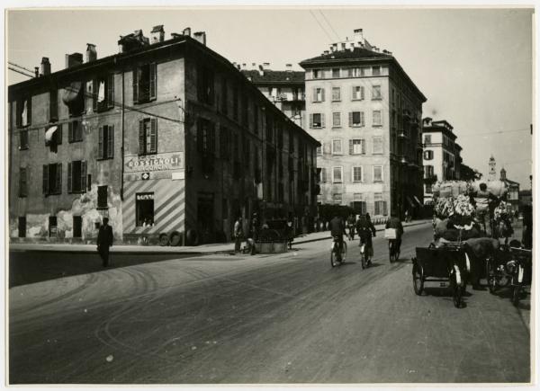 Milano - Via Molino delle Armi, angolo Via Vettabbia - Biciclette, carri, passanti, insegna "Cicli Rossignoli Furgoncini", gommista (Garocchio Fermo?)