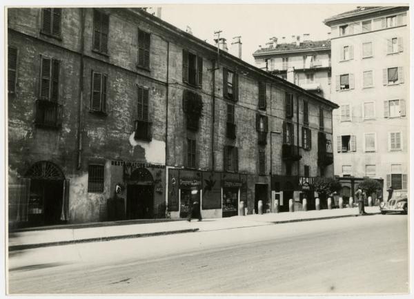 Milano - Via Molino delle Armi - Negozi (restauratore di lampadari, drogheria Siboni,mobili Mario Bariggioli), automobile e passanti