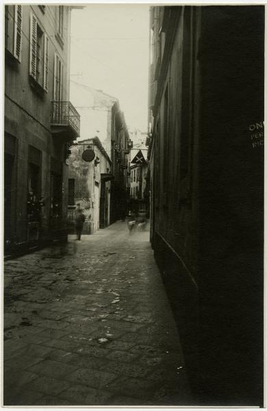 Milano - Via S. Maurilio e imbocco di via Zecca Vecchia - Cartello stradale croce di S. Andrea e passanti