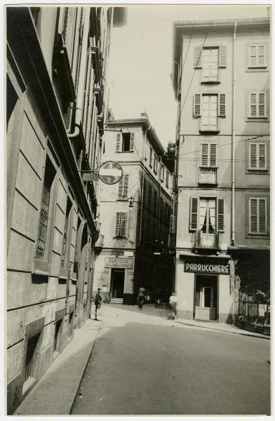 Milano - Incrocio Via S. Zeno/Via Pasquirolo e imbocco di Via Passarella - Passante e bambini, cartello stradale di divieto d'accesso e negozi "PARRUCCHIERE" e "PENSIONE/GALLERIA DEL CORSO"