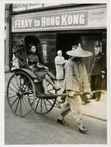 Londra - Giovane cinese su un risciò trascinato da un uomo davanti a un cinema dove viene proiettato il film di Lewis Gilbert "Passaggio a Hong Kong"