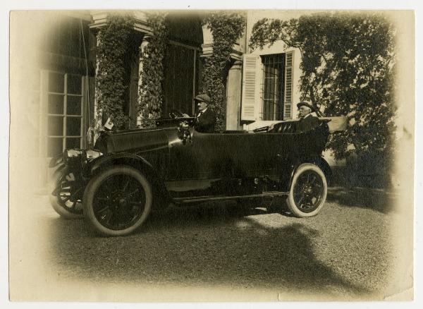 Automobile con autista e passeggero nel cortile di una villa