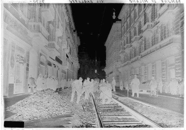 Milano - via Broletto - lavori della linea tramviaria - operai a lavoro - Palazzo Venezia - negozi