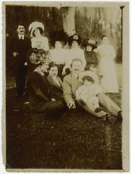 Ritratto di gruppo - Elvira Lazzaroni seduta con altre donne, uomini e Roberto Metlicovitz bambino - Esterno, giardino