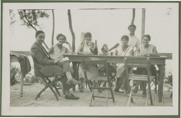 Ritratto di gruppo - Marieda Di Stefano con Antonio Boschi, il fratello Agostino (?), le sorelle Fulvia, Leli, altra donna e bambina seduti attorno a un tavolo - Gabicce Mare