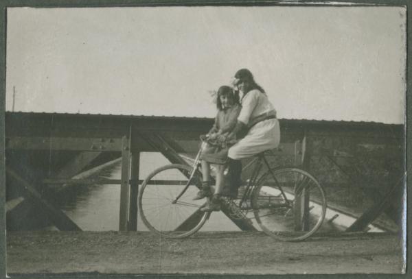 Ritratto femminile - Due ragazze su una bicicletta - Esterno - Ponte - Canale