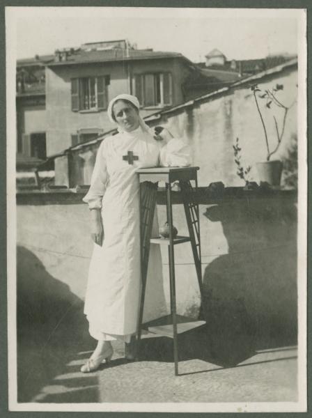 Ritratto femminile - Donna infermiera con mano fasciata su un balcone - Esterno - Città