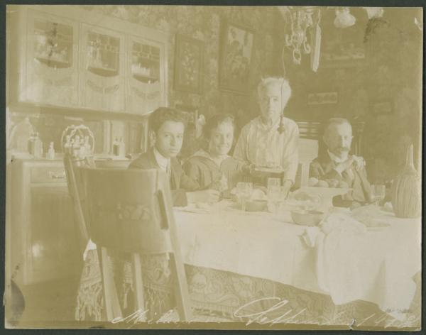 Ritratto di gruppo - Marieda Di Stefano con ragazzo e una coppia di anziani seduti - Tavola imbandita, colazione - Interno - Casa - Sala da pranzo