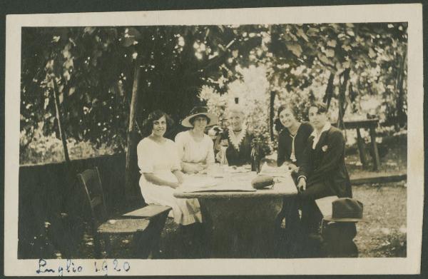 Ritratto di gruppo - Marieda Di Stefano con la sorella Fulvia, altre due donne e un ragazzo seduti a un tavolo - Esterno - Giardino - Colazione