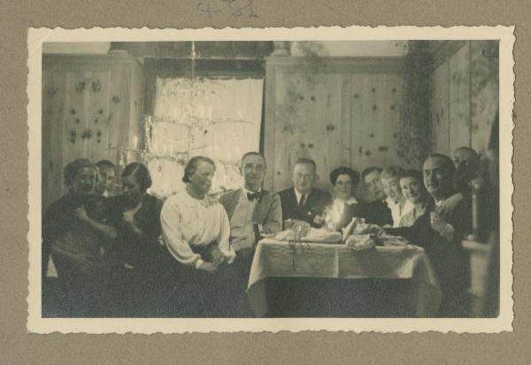 Ritratto di gruppo - Marieda Di Stefano con altre persone seduti al tavolo - Braies: altopiano di Prato Piazza - Interno - Baita in legno - Cenone - Notte di Natale