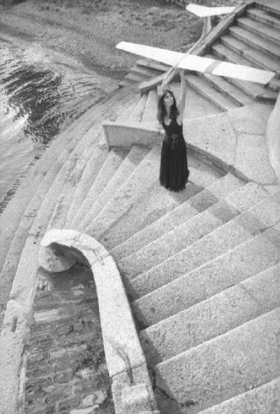 Modella gioca con modellino di aereo su una scalinata. Daniela