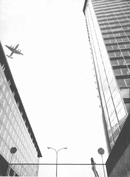Veduta urbana - centro direzionale di via Melchiorre Gioia con figura femminile e aereo sullo sfondo