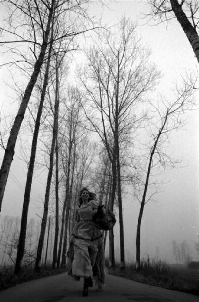 Ritratto femminile - modella indossa abito a balze, mentre corre lungo una strada di campagna. Vanessa