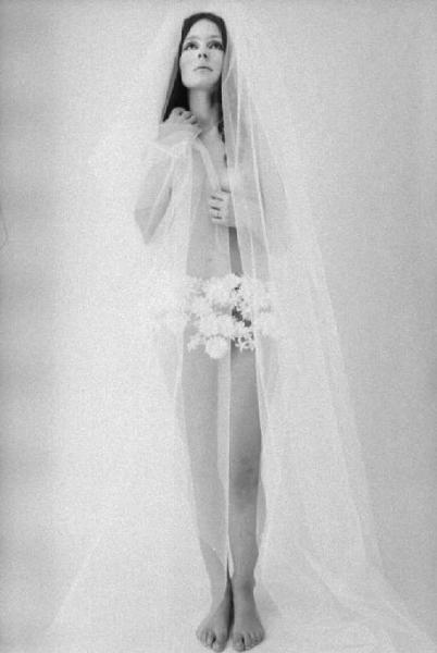 Ritratto femminile - giovane - modella a seno nudo che indossa una minigonna con applicazioni di fiori e velo trasparente. Giuliana