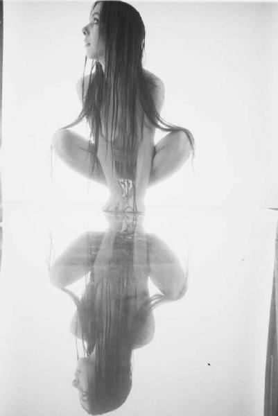 Nudo femminile in studio - figura intera - modella posa sopra uno specchio