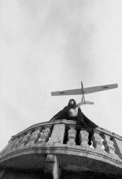 Fotomodella con modellino di aereo posa sopra il parapetto di una villa barocca - esterno