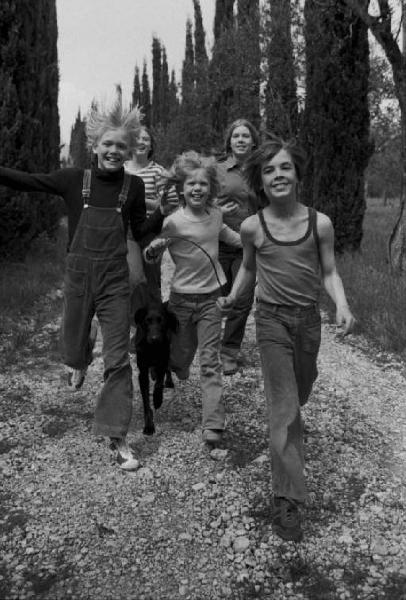 Bambini che corrono lungo una strada di campagna