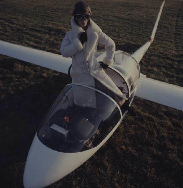 Fotomodella in pelliccia posa all'interno di un aeroplano - primo piano