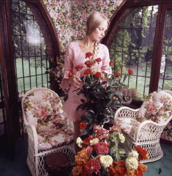 Ritratto femminile - modella con mazzi di fiori e giardino sullo sfondo
