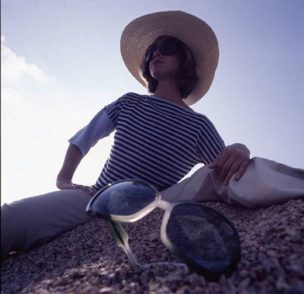 Ritratto di donna - fotomodella posa con occhiale da sole - esterno - primo piano in controluce