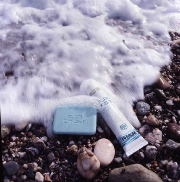 Campagna pubblicitaria prodotti cosmetici - esterno. Un flacone sulla riva della spiaggia - primo piano