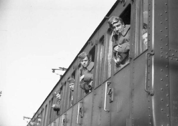 Stazione ferroviaria di Milano. Inizio del viaggio verso l'Africa, militari affacciati al finestrino del treno