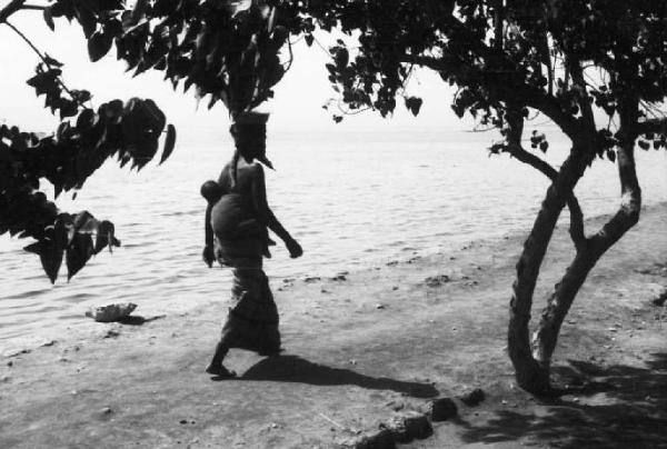 Viaggio in Africa. Massaua - lungomare - viale alberato - donna indigena con bambino in spalla
