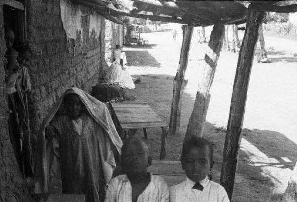 Viaggio in Africa. Villaggio - abitazioni e scene di vita quotidiana - due bambini indigeni in primo piano