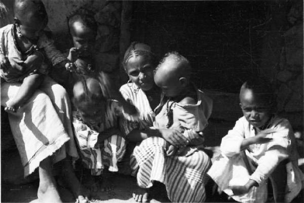 Viaggio in Africa. Insediamento indigeno di Mai Otza - gruppo di fanciulli indigeni davanti alle loro capanne - scorcio