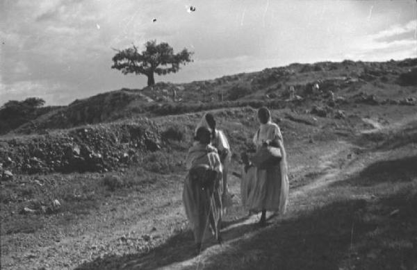 Viaggio in Africa. Tre donne indigene camminano lungo una strada sterrata