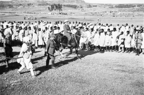 Viaggio in Africa. Ufficiale italiano a cavallo passa in rassegna le truppe indigene schierate in occasione della parata militare nei pressi di Adigrat