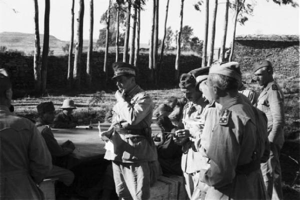 Viaggio in Africa. Militari italiani siedono a un tavolo posizionato in un campo durante una riunione