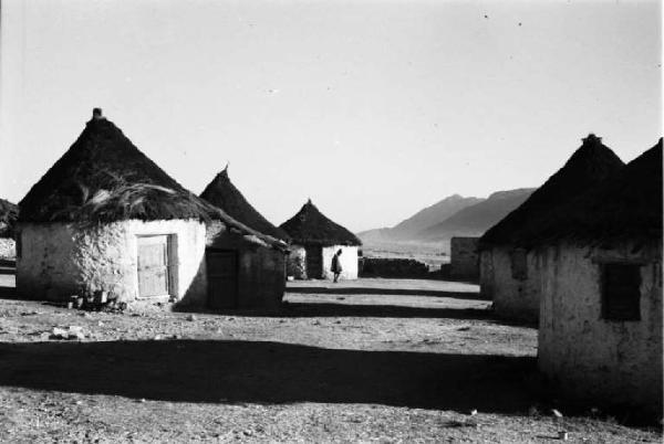 Viaggio in Africa. Scorcio di un villaggio - abitazioni circolari in calce bianca con tetto in paglia: Un uomo in lontananza