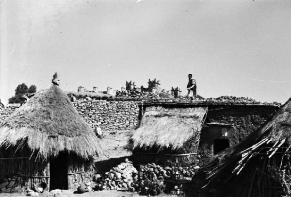 Viaggio in Africa. Esterno della cinta muraria di Macalle [?] - capanne - indigeno cammina lungo le mura