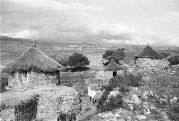 Viaggio in Africa. Quiha: veduta del villaggio, capanne di sasso con tetti di paglia e muretti a secco