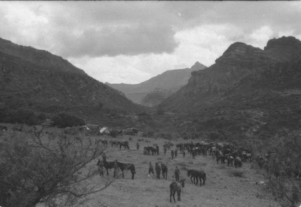 Viaggio in Africa. Paesaggio africano: militari italiani, una compagnia a cavallo e un accampamento di tende posizinate in una radura tra le rocce
