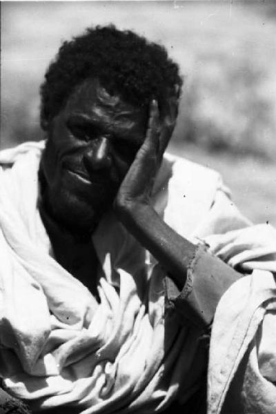 Viaggio in Africa. Ritratto maschile: primo piano di indigeno che appoggia il volto alla mano. Uomo del Negasc